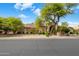 Charming home exterior with a tile roof, mature trees, and desert landscaping at 10892 E Gold Dust Ave, Scottsdale, AZ 85259