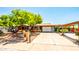 Charming single-story home featuring a well-maintained front yard, mature tree, and a modern garage door at 11215 N 37Th Ave, Phoenix, AZ 85029