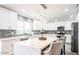 Modern kitchen featuring an island with barstool seating, stainless appliances and sleek white cabinets at 11215 N 37Th Ave, Phoenix, AZ 85029