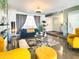 Bright and airy living room with a blue velvet sofa, yellow chairs, and a stylish fireplace at 11215 N 37Th Ave, Phoenix, AZ 85029