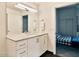 This bright bathroom features a sleek vanity, large mirror, and contemporary fixtures, with a bedroom with a full-size bed to the right at 1130 N 2Nd St # 401, Phoenix, AZ 85004