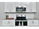 The well-lit kitchen features updated stainless appliances, stylish backsplash, white cabinets, and modern countertops at 1130 N 2Nd St # 401, Phoenix, AZ 85004