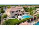 Aerial view of a backyard featuring a pool, outdoor kitchen, fire pit, and lush landscaping at 1179 E Regent Dr, Gilbert, AZ 85298