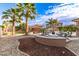 Backyard features a fire pit with Adirondack chairs, palm trees, and an outdoor kitchen by the pool at 1179 E Regent Dr, Gilbert, AZ 85298