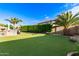 This meticulously maintained backyard features an outdoor kitchen, verdant artificial grass, and a built-in BBQ at 1179 E Regent Dr, Gilbert, AZ 85298