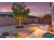 This landscaped backyard with a gravel area and a stone paver walkway is illuminated by garden lights at 1179 E Regent Dr, Gilbert, AZ 85298