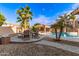 Backyard with a fire pit, chairs, desert landscaping, palm trees and a covered outdoor kitchen near the pool at 1179 E Regent Dr, Gilbert, AZ 85298