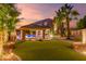 Inviting backyard features lush landscaping, a covered patio, a sparkling pool, and elegant outdoor lighting at 1179 E Regent Dr, Gilbert, AZ 85298