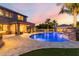 Backyard showcasing a luxurious pool, cabana with outdoor kitchen, and lush landscaping at 1179 E Regent Dr, Gilbert, AZ 85298