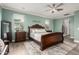 Spacious bedroom featuring wood floors, large windows, and an ornate sleigh bed, plus a ceiling fan and modern lighting at 1179 E Regent Dr, Gilbert, AZ 85298