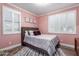 Cozy bedroom with pink walls, white plantation shutters, and a comfortable bed, creating a tranquil retreat at 1179 E Regent Dr, Gilbert, AZ 85298