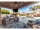 Covered patio with comfortable seating and a view of the pool and lush backyard landscaping at 1179 E Regent Dr, Gilbert, AZ 85298