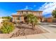 Inviting two-story home featuring lush desert landscaping and a charming desert stream rock feature in the front yard at 1179 E Regent Dr, Gilbert, AZ 85298