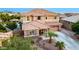Exterior view of a two-story home with a tile roof, desert landscaping, and a two-car garage at 1179 E Regent Dr, Gilbert, AZ 85298