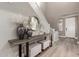 Bright foyer with stylish decor, including decorative vases, a round mirror, and a staircase with white railings at 1179 E Regent Dr, Gilbert, AZ 85298