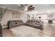 Spacious living room with a sectional sofa, ceiling fan, and views into the open kitchen at 1179 E Regent Dr, Gilbert, AZ 85298