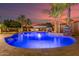 Stunning backyard pool with water feature, cabana, and lush tropical landscaping perfect for entertaining at 1179 E Regent Dr, Gilbert, AZ 85298