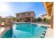 The backyard shows a refreshing pool with barstool seating and a well-manicured lawn at 1179 E Regent Dr, Gilbert, AZ 85298