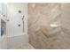 Modern tiled shower featuring decorative tiling in a herringbone pattern, along with updated fixtures and ample space at 1179 E Regent Dr, Gilbert, AZ 85298