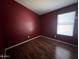A cozy bedroom with wood floors is brightened by natural light from the window at 15329 W Melissa Ln, Surprise, AZ 85374