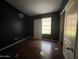 A dark bedroom with wood flooring features a window offering natural light at 15329 W Melissa Ln, Surprise, AZ 85374