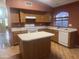 Traditional kitchen featuring wooden cabinets, center island, white appliances, and lots of counterspace at 15329 W Melissa Ln, Surprise, AZ 85374
