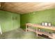 Basement with green walls and a wooden workbench, offering ample space for projects and storage at 1609 E Williams N St, Tempe, AZ 85281