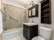 Well-lit bathroom featuring a shower-over-tub combination with glass doors, and dark wood vanity at 1609 E Williams N St, Tempe, AZ 85281