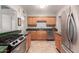 Well-lit kitchen featuring wood cabinets, granite countertops, and stainless steel appliances at 1609 E Williams N St, Tempe, AZ 85281
