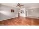 Open-concept living room features hardwood floors, a ceiling fan, and seamless flow to kitchen at 1609 E Williams N St, Tempe, AZ 85281