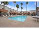 Sparkling community pool is surrounded by palm trees and lounge chairs at 16510 E Palisades Blvd # 42, Fountain Hills, AZ 85268