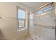 This bathroom features an enclosed glass shower, neutral walls, and a window that lets in natural light at 16540 W Culver St, Goodyear, AZ 85338