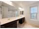 Bathroom featuring double sinks, large mirror, vanity and a shower-tub combo at 16540 W Culver St, Goodyear, AZ 85338