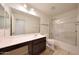 Bathroom featuring large mirror, vanity and a shower-tub combo with glass doors at 16540 W Culver St, Goodyear, AZ 85338