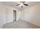 Carpeted bedroom featuring closet with sliding doors, a ceiling fan and neutral walls at 16540 W Culver St, Goodyear, AZ 85338