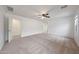Spacious bedroom features a ceiling fan, neutral walls and carpet, and a doorway to another room at 16540 W Culver St, Goodyear, AZ 85338