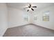 Carpeted bedroom featuring ceiling fan and two windows providing natural light at 16540 W Culver St, Goodyear, AZ 85338