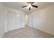Bright carpeted bedroom with a ceiling fan, closet and a window at 16540 W Culver St, Goodyear, AZ 85338