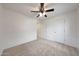 This bedroom features carpet flooring, a ceiling fan, neutral paint and two doors for simple design at 16540 W Culver St, Goodyear, AZ 85338