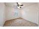 Carpeted bedroom features a ceiling fan and a window providing natural light at 16540 W Culver St, Goodyear, AZ 85338