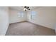 Neutral bedroom with carpet flooring, two windows, a ceiling fan and white walls, for a simple room at 16540 W Culver St, Goodyear, AZ 85338