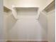 Walk-in closet featuring carpet flooring, white walls, and open shelving to maximize space at 16540 W Culver St, Goodyear, AZ 85338