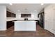 Modern kitchen featuring a large island, dark wood cabinets, and stainless steel appliances, perfect for culinary enthusiasts at 16540 W Culver St, Goodyear, AZ 85338