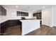 Sleek kitchen showcasing an island, dark wood cabinetry, quartz countertops, and modern stainless steel appliances at 16540 W Culver St, Goodyear, AZ 85338