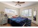 Bright bedroom with a ceiling fan, wood floors and a bed with blue covers and several decorative pillows at 1712 E Montebello Ave, Phoenix, AZ 85016