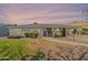 Charming single-story home with lush greenery, a brick facade, and a red front door under a colorful sky at 1712 E Montebello Ave, Phoenix, AZ 85016