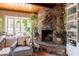 Charming living room with a stone fireplace, and beautiful plants; the perfect place to unwind at 1712 E Montebello Ave, Phoenix, AZ 85016