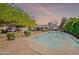 Backyard swimming pool surrounded by concrete with backyard area and trees with a beautiful sunset sky backdrop at 1712 E Montebello Ave, Phoenix, AZ 85016