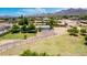 Expansive aerial view capturing the property, showcasing the lush landscaping and scenic mountain views at 18051 E Happy Rd, Queen Creek, AZ 85142