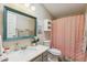 Well-lit bathroom with a patterned shower curtain and a modern vanity with a framed mirror at 18051 E Happy Rd, Queen Creek, AZ 85142